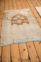 Angled view of a vintage Oushak rug highlighting its soft, worn texture and organic, contoured shape.