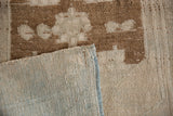 View of the hand-knotted foundation and side cord on a vintage distressed Oushak rug.