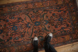 Overhead view of the vintage Persian Mehrivan rug showing its low pile and complex floral design.