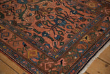 Intricate floral arabesque and boteh borders on a dusty rose vintage Mehrivan rug.