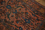 Hand-knotted detail of sapphire blue and mallard green floral motifs on a dusty rose ground.