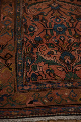 Floral arabesque and boteh motif border in sapphire blue on a dusty rose vintage Persian rug.