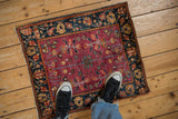 Antique Farahan Sarouk rug showing the rich cochineal field and traditional navy blue palmette border.