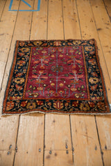 High-angle view of an antique Farahan Sarouk mat with a cochineal field and intricate navy border.