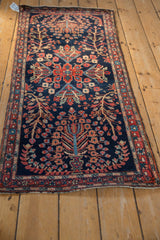 Close-up of the antique Farahan Sarouk runner's navy field with blossomed flowers and unique serpent border.