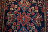 Antique Farahan Sarouk rug detail: navy field, madder red floral motif, serpent border.