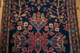 Antique Farahan Sarouk runner's navy blue field with red flowers, green vines, serpent border.