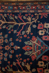 Transitional antique Farahan Sarouk rug, navy field with blossomed flowers and serpent border.
