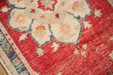 Detailed view of a distressed Oushak rug's mostly even wear across the cherry red pile.
