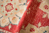 Soft, distressed pile texture of a hand-knotted cherry red and beige Oushak rug.