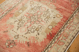 Cloud band motifs and floral bouquets in the ivory medallion of a distressed Turkish Oushak rug.