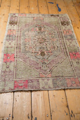 Angled view of a vintage distressed Turkish Oushak rug with a time-softened patina.