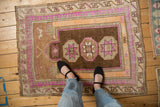 Distressed Turkish Kars rug corner with faded magenta and tangerine pawn border detail.