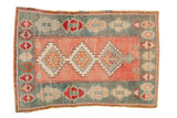 Distressed vintage Oushak rug with triple serrated medallions in a dusty rose, faded teal, and red palette.