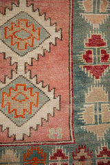 Hand-knotted Oushak rug detail with geometric medallions in dusty rose, teal, and tangerine.