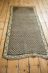 Distressed Kars rug corner features brown niche with faint animal figure, platinum lattice, and wavy border.