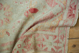 Textured close-up of a distressed Oushak showing worn pile and foundation.