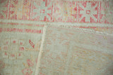 Distressed Oushak rug corner showing wear to knot heads and the hand-knotted foundation.
