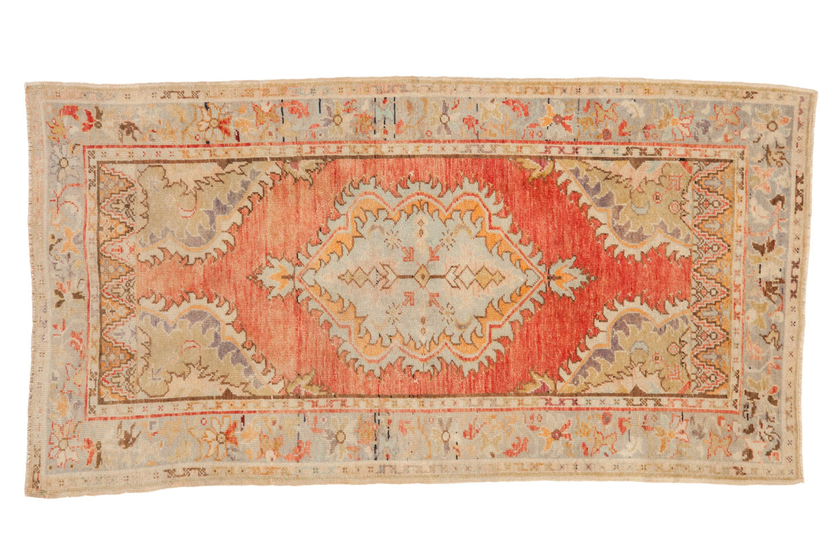Vintage distressed Oushak runner with a scalloped medallion in dusty blush, sage green, and pale orange.