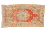 Vintage distressed Oushak runner with a scalloped medallion in dusty blush, sage green, and pale orange.