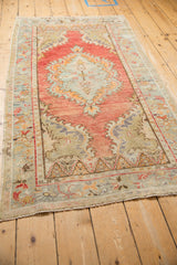 Distressed Oushak runner from an angle, showing the abrashed blush field and seafoam medallion.