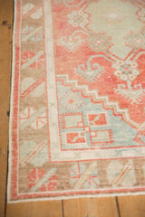 Geometric border details of a vintage Oushak in pale bronze, watermelon, and powder blue hues.