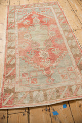 A vintage Oushak runner's geometric medallion and distressed low-pile texture from a high angle.