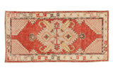 Vintage distressed Oushak rug runner with a geometric diamond medallion in cherry red, platinum, and charcoal.