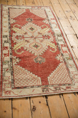 Angled view of a distressed Oushak runner's geometric medallion and time-softened cherry red field.