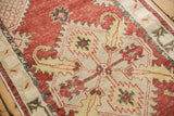Serrated leaf and palmette design detail on a distressed vintage Oushak rug with low, even wear.