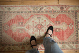 The soft, worn texture of a vintage distressed Oushak rug runner from an overhead perspective.