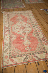 Angled view of a distressed Oushak runner showing its low pile and stepped geometric medallion design.