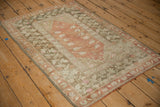 Vintage distressed Melas rug with terra cotta roses and olive floral border.