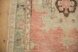 Textured distressed pile of a vintage Oushak rug, showing blush, blue, and beige hues.