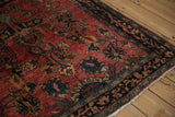 Corner view of a fine Sarouk rug showing vivid teal and gold motifs on a ruby field.