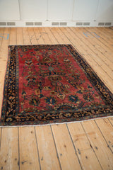 High-angle view of a fine antique Sarouk rug displaying its allover floral pattern on a ruby red field.