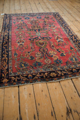 Long angle view of an antique Sarouk rug's intricate palmette and vine design.