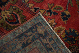 Close-up of the antique Sarouk rug's hand-knotted back, alongside its short, ruby red pile.
