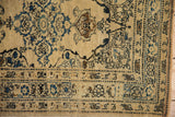 Time-softened patina on the low pile and ornate floral border of an antique Tabriz rug.