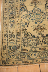 Intricate sapphire blue border and worn, hand-knotted pile of an antique Persian Tabriz rug.