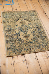 Angled view of an antique Tabriz rug, showcasing the book cover-style medallion and ornate borders.