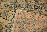 A corner view of the antique Tabriz rug's hand-knotted reverse and its low, even-wear pile.