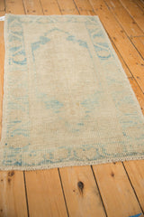 Distressed Oushak rug's ivory and sky blue pile, showing mostly even wear to knot heads.