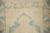 Textured pile with ivory and sky blue geometric patterns, showing even wear and abrashes.