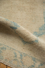 Distressed textured pile of a Turkish Oushak rug, featuring ivory and sky blue hues.