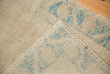 Distressed Oushak pile texture with worn knot heads, sky blue motifs, and side selvage.