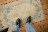 Distressed Oushak runner texture featuring worn ivory and sky blue geometric patterns.