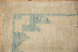 Distressed Oushak rug's textured pile showing sky blue serrated pattern and knot heads.
