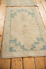 Distressed Oushak rug runner with textured pile and decorative sky blue geometric motifs.