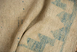 Distressed Oushak rug texture with worn ivory and sky blue knot heads.